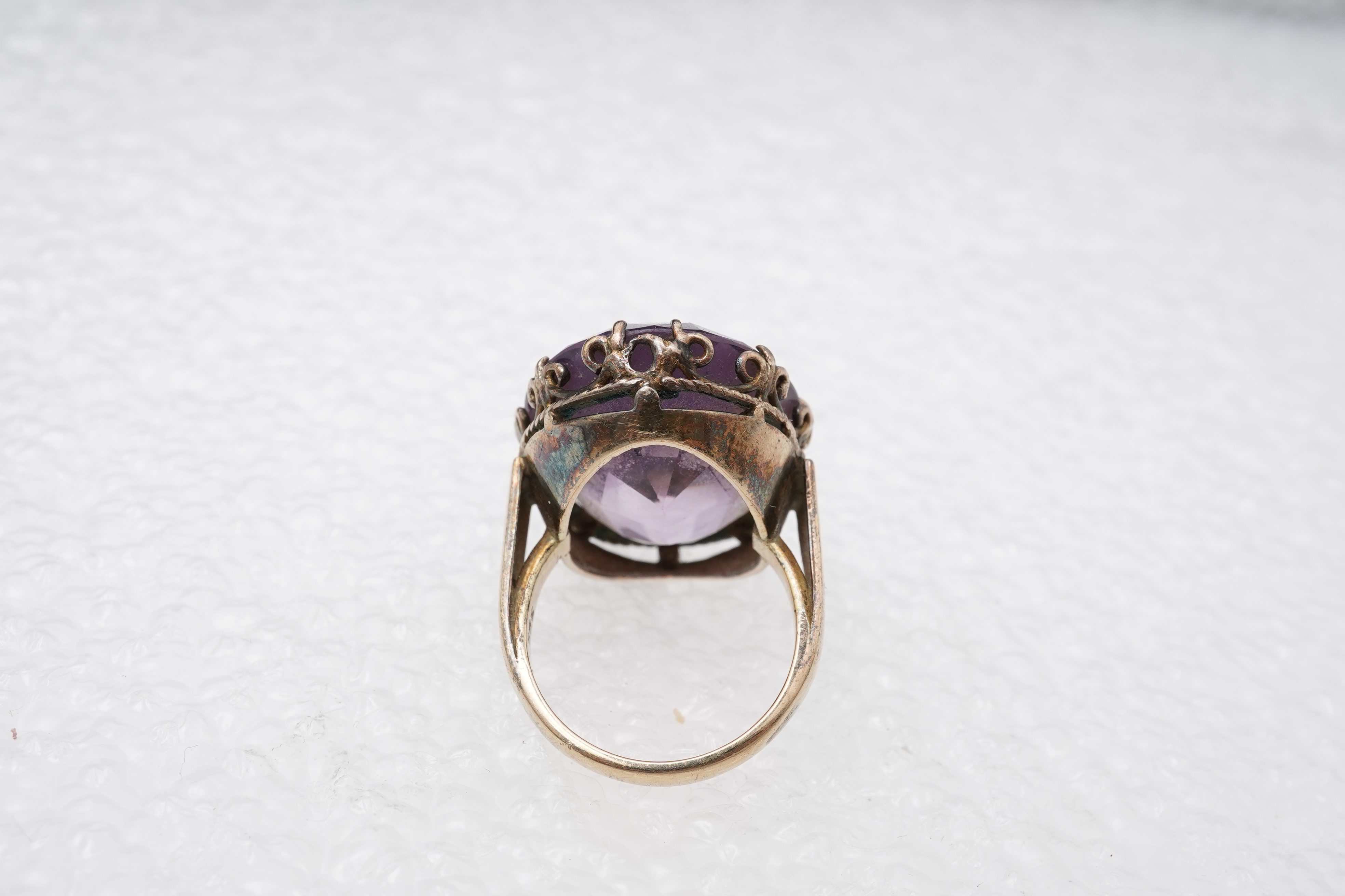 An amethyst ring, necklace and pendant, comprising: an oval amethyst set in a floral gilt silver necklace, length 32cm; an oval amethyst and seed pearl pendant, length 3.7cm; and a ring set with an oval amethyst, mounted